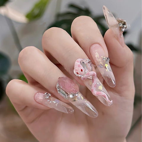 Manucure faite à la main pure portant un faux ongle autocollant glace pure à travers un patch de manucure bébé serpent rose m3331214